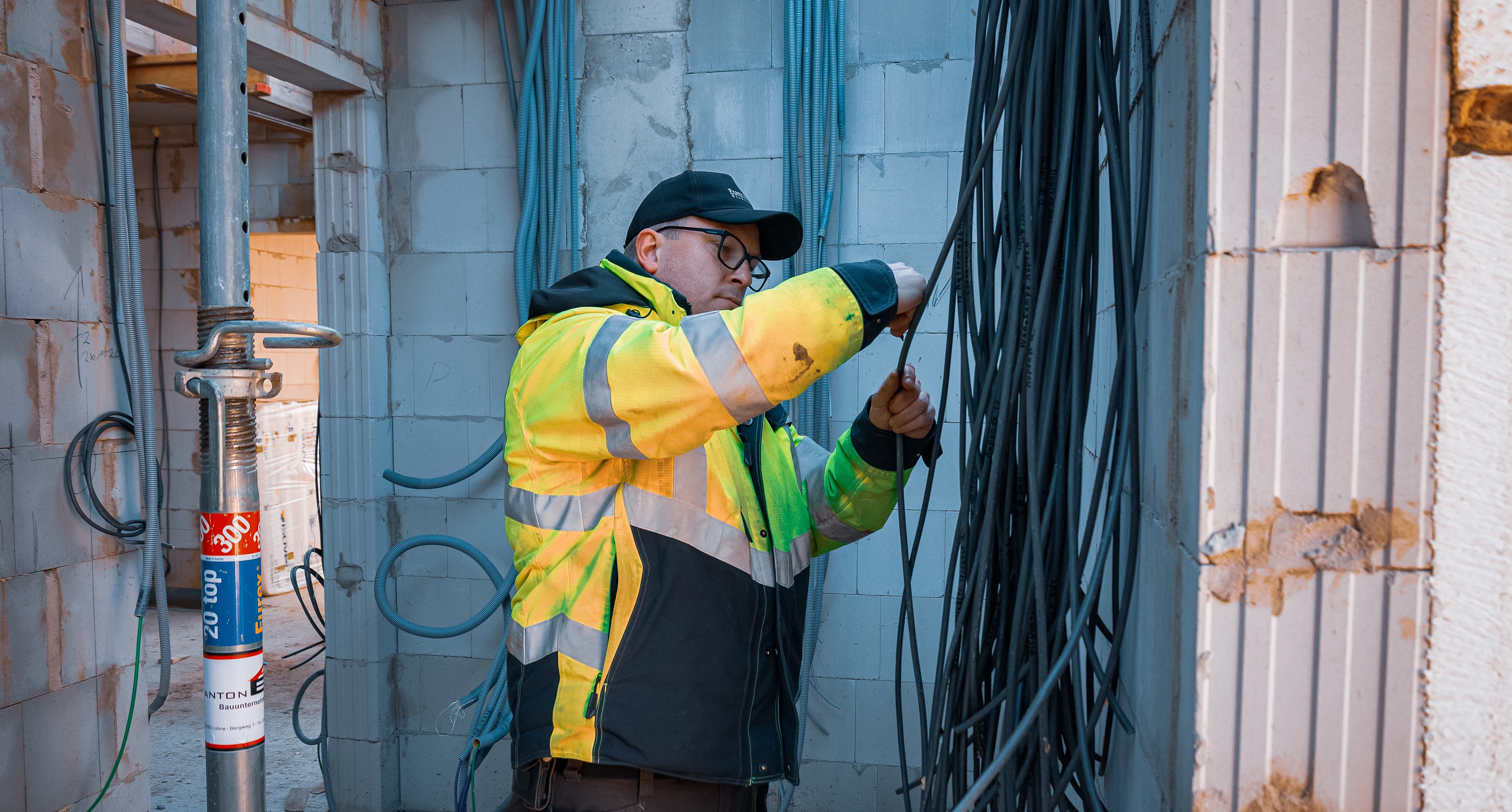 Ein Mitarbeiter prüft die Elektroinstallation in einem Rohbau