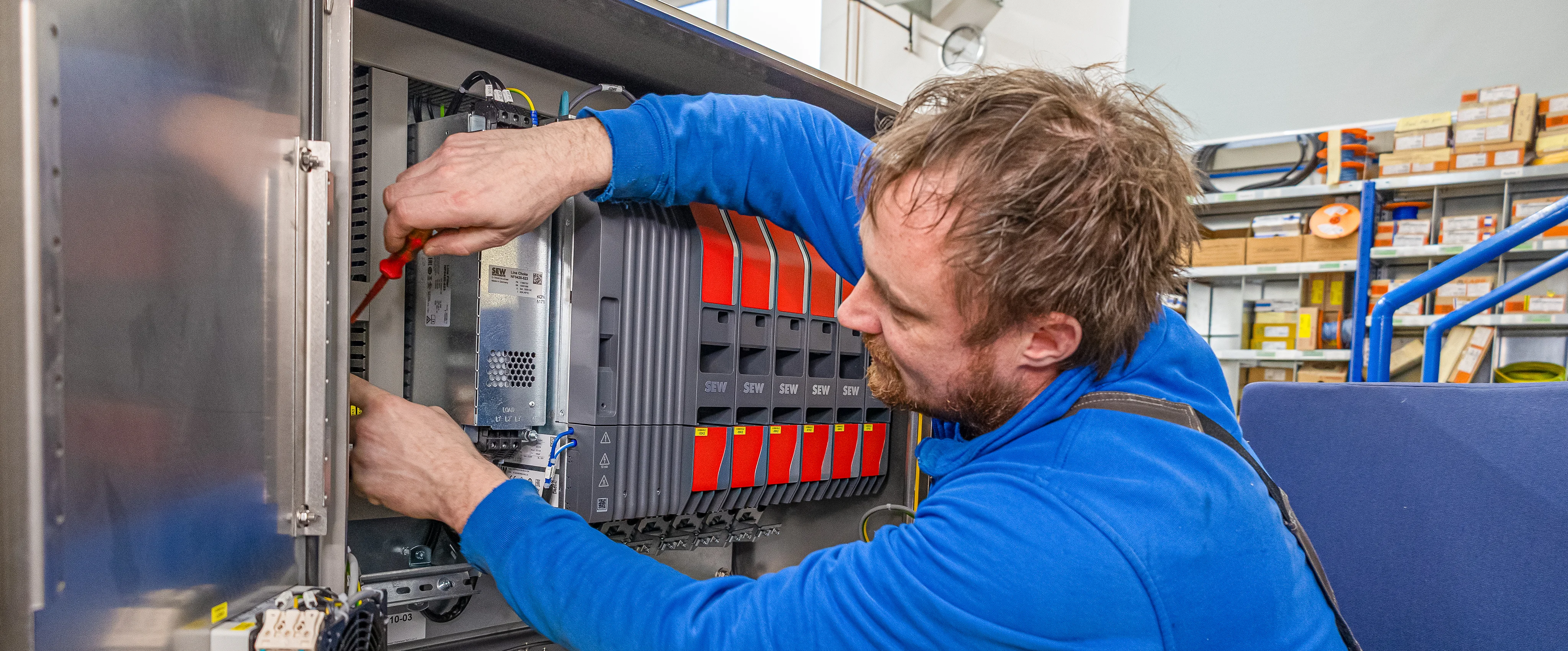 Blick über die Schulter eines Mitarbeiters der Firma Holthaus an einem Schaltschrank