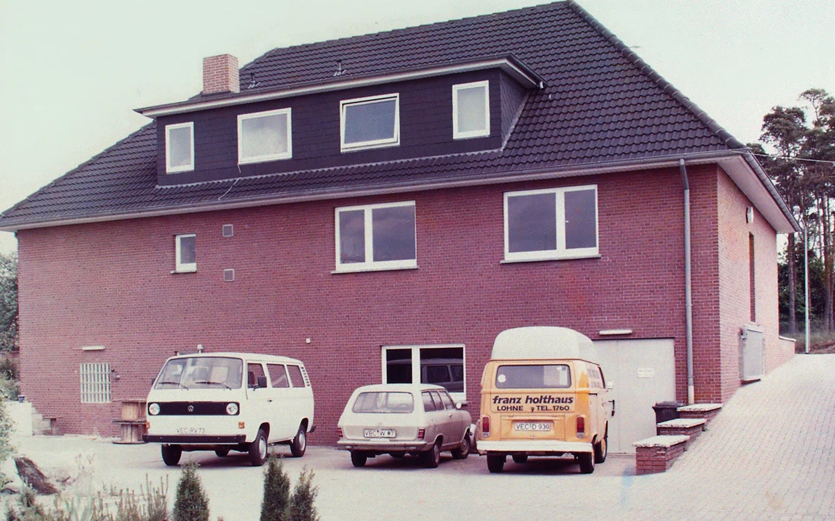 Das alte Firmengebäude mit mehreren Fahrzeugen davor